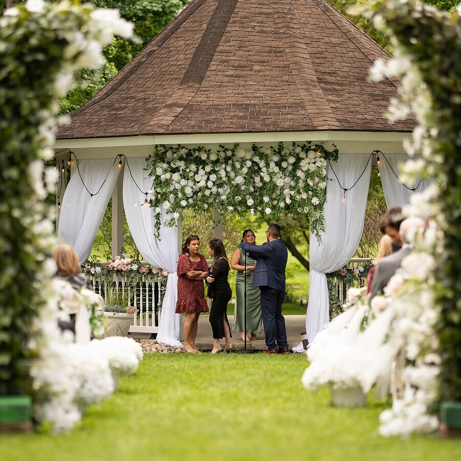 Wedding ceremony under a floral arch at the gazebo