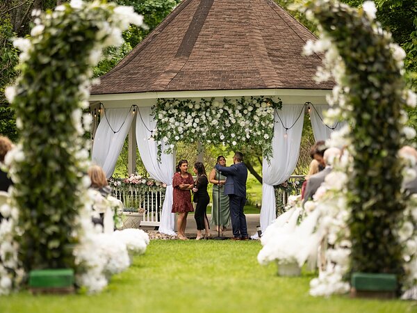 Wedding ceremony under a floral arch at the gazebo, Chef's Event Center near Rochester, NY