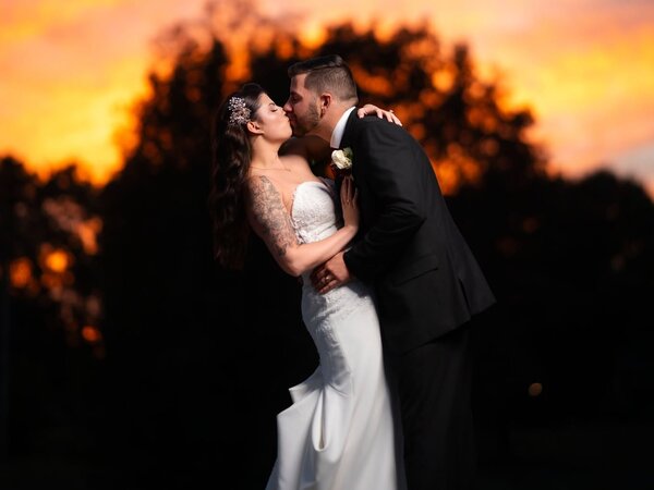 A couple kisses at sunset on the grounds, Chef's Event Center near Rochester, NY